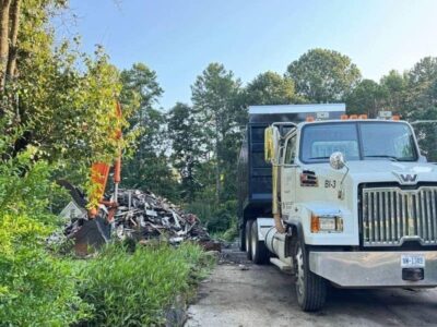 dump truck parked beside a debris pile during cleanup