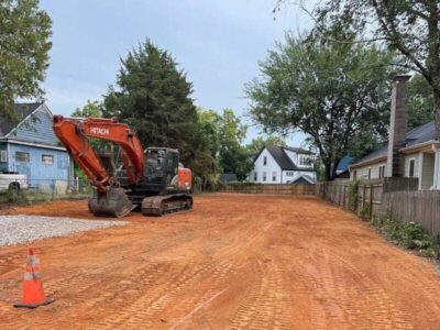 excavator on a cleared residential lot with graded soil
