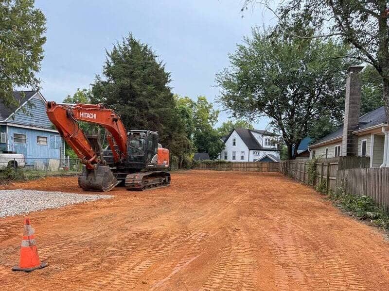 excavator on a cleared residential lot with graded soil