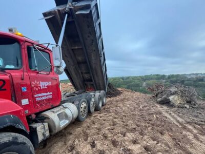 Dump truck unloading material on a prepared construction site