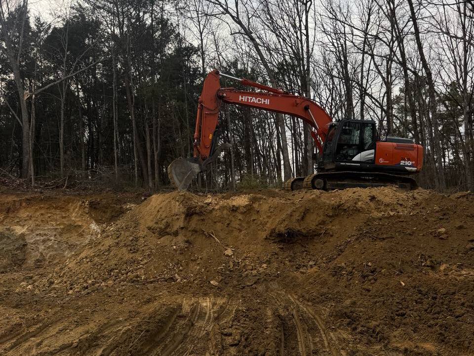 Excavator working on an active excavation site with exposed soil