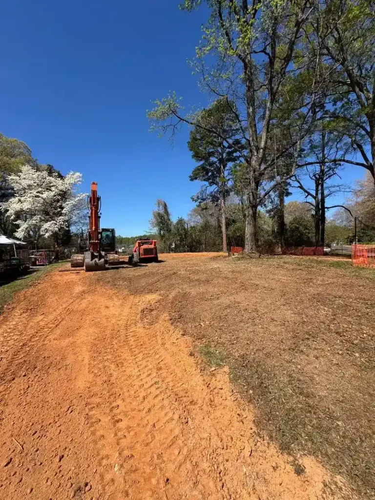 Residential site preparation with rough grading beside a new home in Charlotte NC